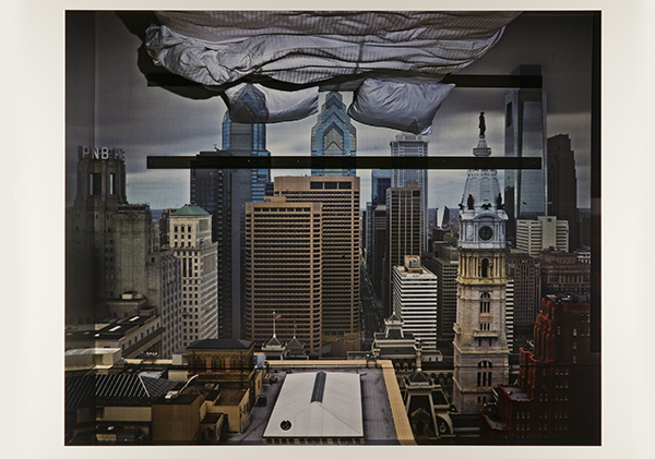 Photograph by Abelardo Morell titled Camera Obscura: View of Philadelphia from Loews Hotel Room #3013 with Upside Down Bed (2014). Philadelphia skyline shown right-side up projected into a hotel room shown upside down as a camera obscura.