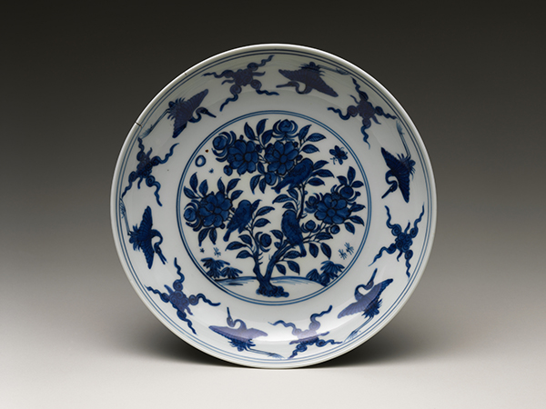 Jingdezhen ware porcelain Dish with Flowers and Birds (1565). Blue-and-white ware dish with cranes and flaming pearls around the rim and a flowering tree in the center.