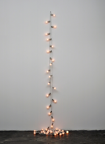 Installation by Felix González-Torres titled Untitled (Toronto) (1992). Doubled strand of lightbulbs attached to a wall and pooling on the floor.