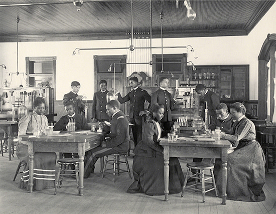 Photograph by Frances Benjamin Johnston titled Physics. Seniors Studying Osmose (1899-1900). Black-and-white photograph of students in a science classroom.