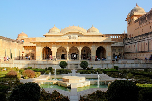 Amer Fort, Jaipur, India (1562-1592). Water feature with fountains in a garden in front of a building with columns and domes.