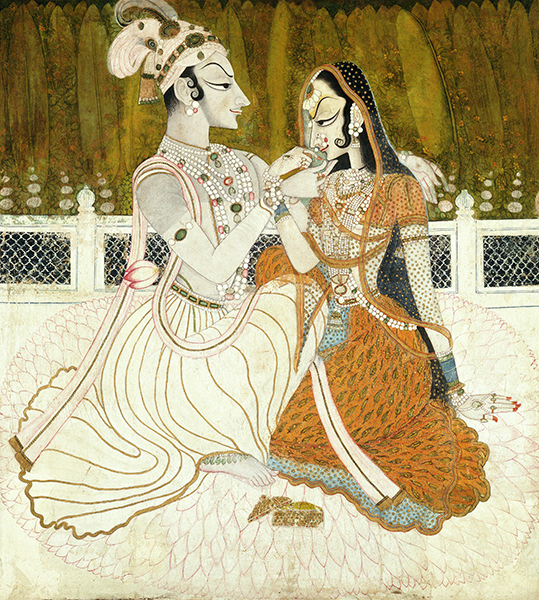 A seated, affectionate couple on a balcony wearing fine clothing and jewelry.