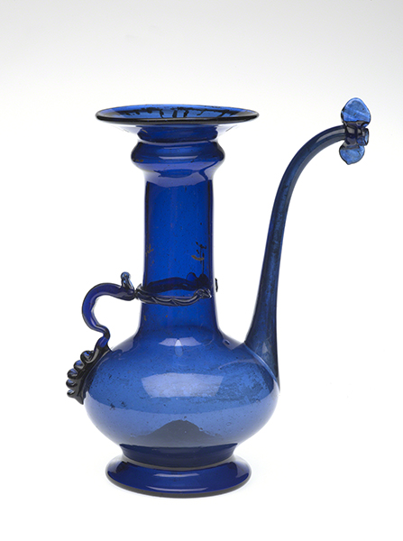 Glass ewer from Iran (1700s). Cobalt blue ewer form with a flaring mouth and spout decorated with an applied butterfly.