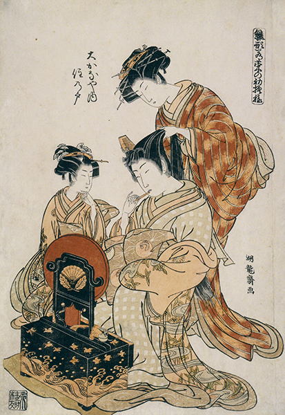 Woodblock print by Isoda Koryusai titled The Courtesan Okanaya (ca. 1775). Standing female figure combs a seated woman's hair, who paints her lips while a third woman watches.