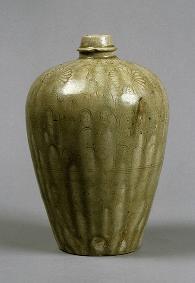 Stoneware wine flask from the Kamakura period in Japan. Vessel with green-yellow glaze and incised chrysanthemum blossom design.