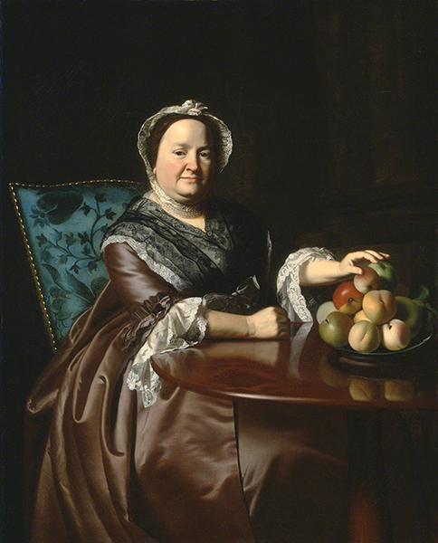 Oil painting by John Singleton Copley titled Mrs. Ezekiel Goldthwait (Elizabeth Lewis) (1771). Portrait of a seated older woman wearing a white bonnet, black shawl, and brown satin dress reaching for fruit in a bowl.