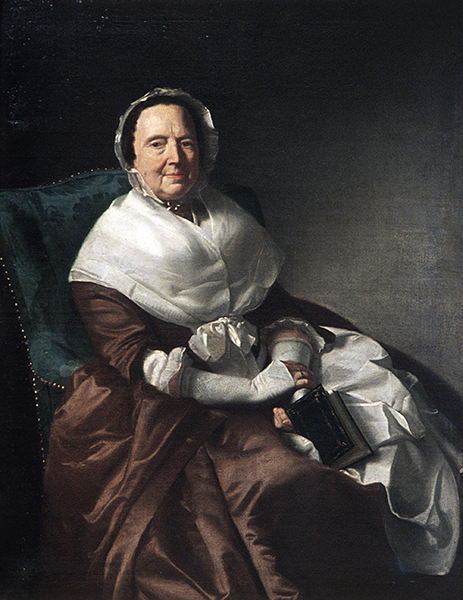 Portrait of a seated older woman wearing a white bonnet, white shawl, and brown satin dress holding a book in her lap.