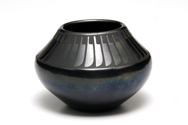 Ceramic jar by Maria Martinez titled San Ildefonso Jar (Jar with Feather Design) (1964). Black-on-black ware with jar with burnished abstract feather designs around the shoulder and irredescent effects on the bottom section.