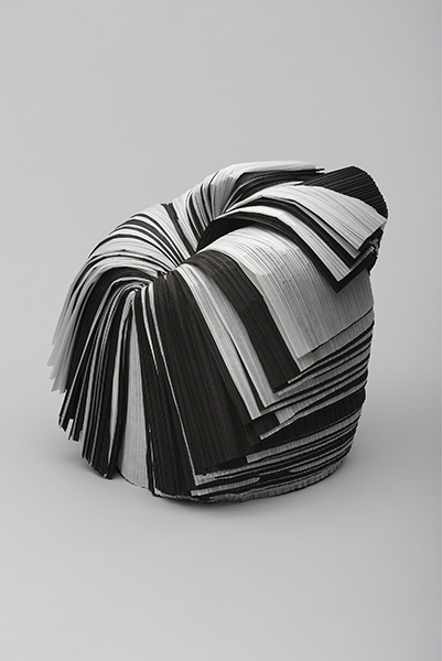 Chair designed by Oki Sato titled Cabbage Chair. Chair made from layers of black and gray paper.