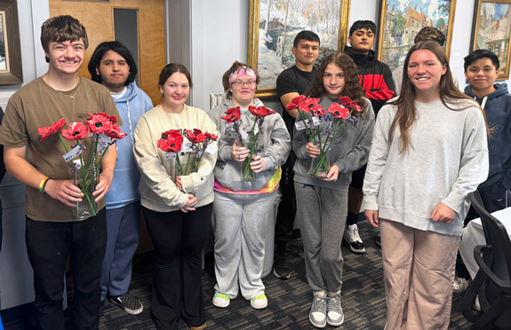 Students with ceramic poppies created for veterans.
