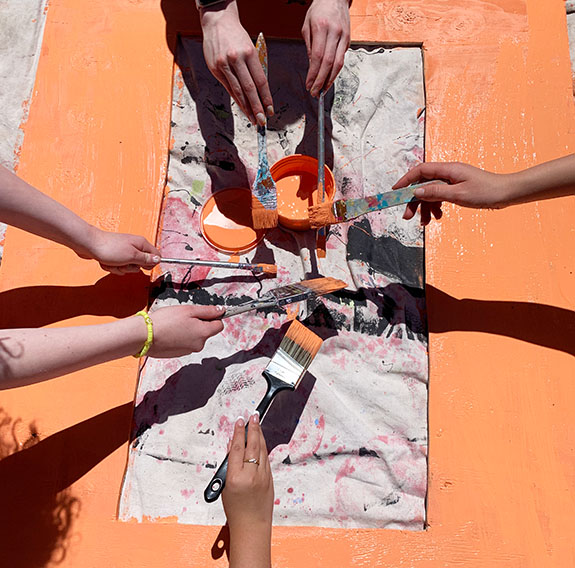 Calgary Girls Charter School students activate the play areas outside their school with painted plywood fence panels.