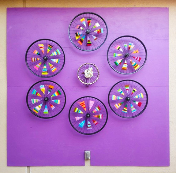 Fourth-grade students wove yarn through bicycle wheel spokes to create this colorful installation.