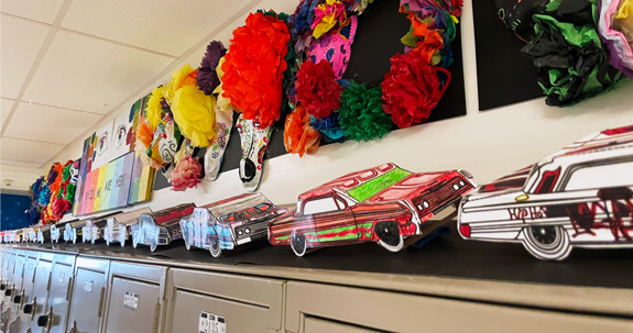 The completed lowriders were displayed on a paper roadway atop studentsʼ lockers.