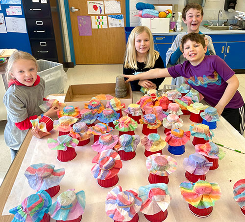 Nora F., Nora W., Owen, and Justin pose for a picture with Dale Chihuly–inspired coffee filters.